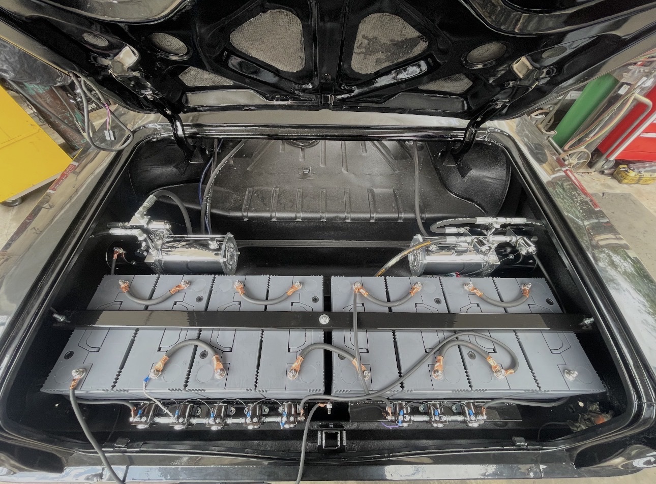 Lowrider hydraulic trunk setup with batteries and pumps