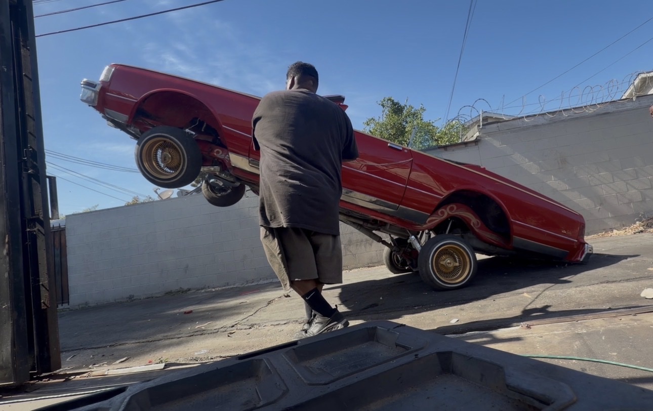 Red lowrider hopper outside the shop